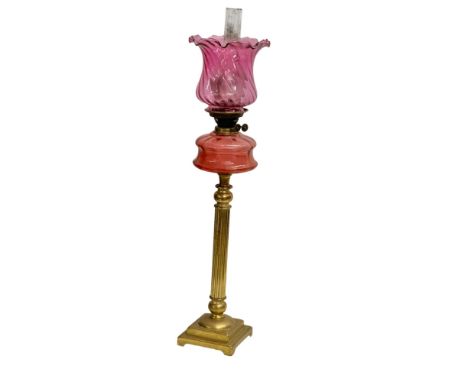 A large Victorian oil lamp with Cranberry Glass bowl, brass column and later shade. 89cm 