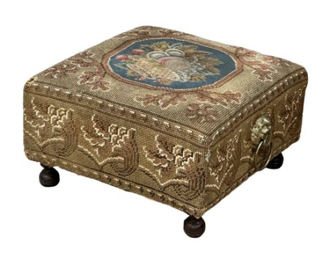 A Victorian tapestry footstool with brass lion mask ring handles. 36x36x21cm 