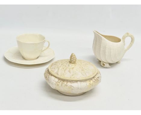 3 pieces of 4th period Belleek Pottery. A ‘Neptune’ cream jug 13x10.5cm. A ‘Tridacna’ cup and saucer. A powder bowl with cove