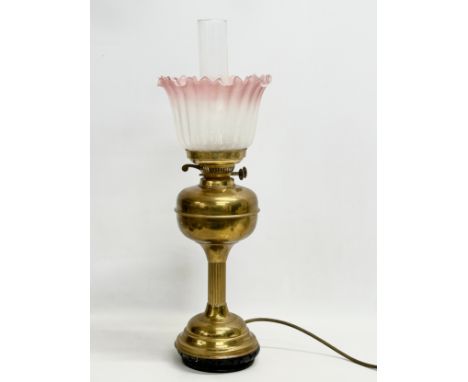 A large early 20th century brass electrified oil lamp with glass shade. 61cm 