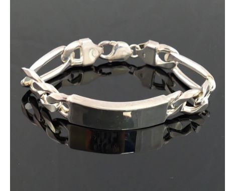 A heavy silver identity bracelet, the rectangular panel 13mm wide with Figaro linksWe are pleased to be offering this lot fro