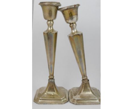 A pair of silver candlesticks with weighted bases, a pair of small silver trumpet-shaped vases, also with weighted bases, a s