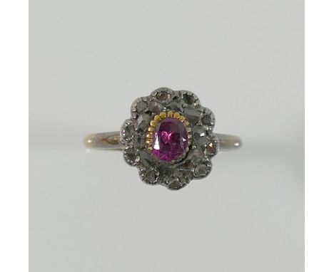 A 19th century diamond and garnet oval cluster ring, the central oval garnet set within a chip-cut diamond surround, to a yel