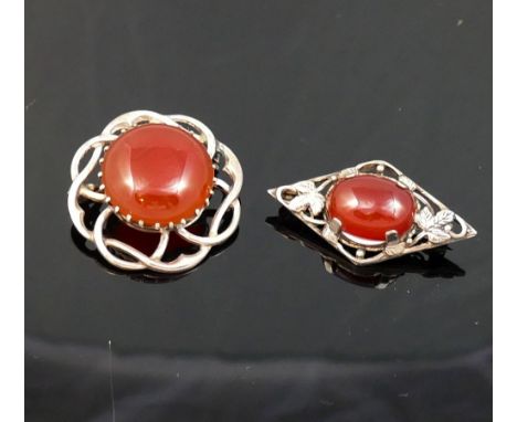 A selection of carnelian jewellery comprised of a circular openwork brooch, another brooch, a bracelet, a pair of stud earrin