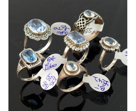 A collection of 12 Swiss blue topaz set rings, including some set with marcasite, most stamped 'silver' or '925' of varying s