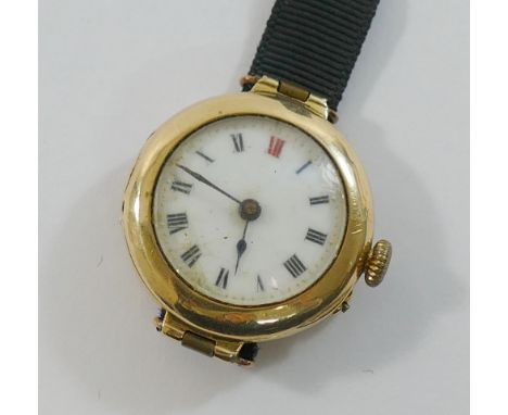 A ladies 15 carat gold cased wrist watch, with white enamel dial, ribbon strap with clasp stamped '9CT', 18.3g gross, and a 9