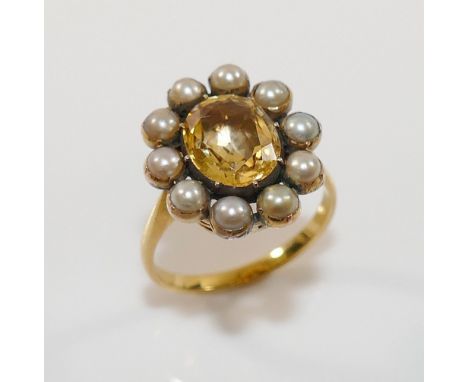 A 19th century gold, yellow topaz and half pearl oval cluster ring, the oval mixed cut topaz in closed foil back setting, wit