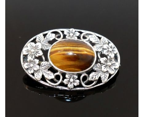 Four items of tiger's eye jewellery comprised of a large single stone ring, a circular openwork brooch and two other brooches