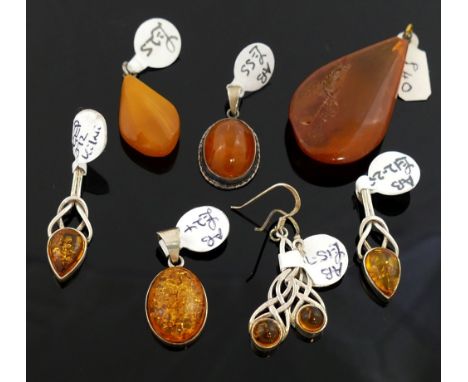 A selection of amber jewellery comprised of a butterscotch amber pendant, 2.6cm long, a larger clarified amber pendant, a pai