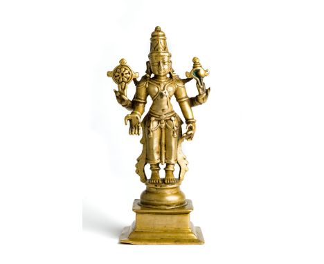 A BRASS FIGURE OF VISHNU, DECCAN, SOUTHERN INDIA, CIRCA 18TH CENTURY  the four-armed deity standing on a circular base on rai