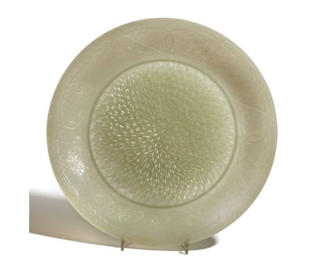 A CHINESE CARVED JADEITE DISH, 20TH CENTURY  the shallow curved sides rising from a short straight foot to a flaring rim, car