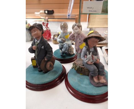 A Nao figure of a pyjama wearing boy holding Teddy bear together with another of boy seated with rabbit & two further Spanish