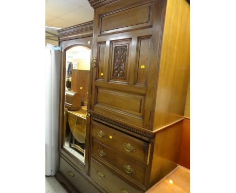 An Edwardian compact oak mirror doored wardrobe with carved decoration & a bank of drawers with brass handles