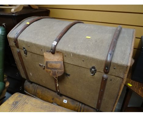 Vintage canvas dome top travel trunk with wooden banding together with an internal shelf