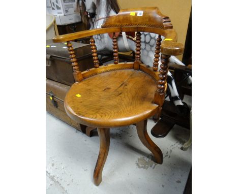 A vintage light oak with carved decoration & spindle supports drum-style office / captain's chair
