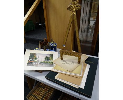 A gilt decorated wooden table easel & a parcel of unframed watercolours & prints together with a large reproduction of a sixt