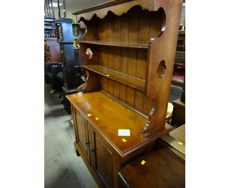 A compact vintage polished wood dresser, a two-shelf rack with a two-cupboard base