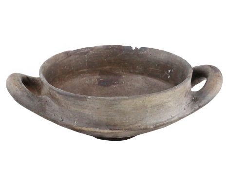 A two-handled clay vesselEtruria, 9th – 8th century BC; diam. cm 17,5; alt. cm 8; A grey clay bowl with a round rim, deep bas