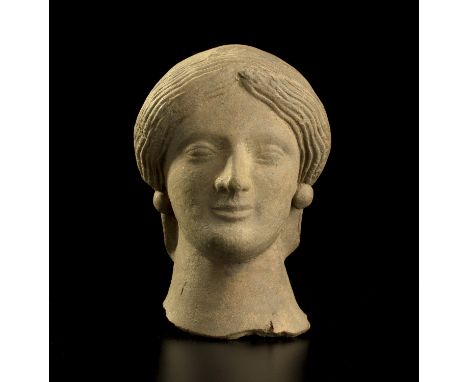 A refined portrait of a female Magna Graecia, early 5th century BC; alt. cm 12; A beautiful female head cast with a mould, de