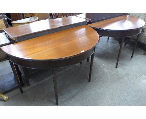 A pair of George IV mahogany demi-lune console tables 