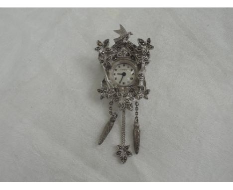 A white metal and marcasite brooch watch stamped 925  in the form of a cuckoo clock with hunting interest