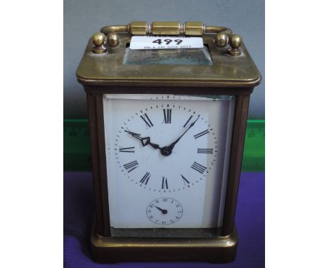 An early 20th century brass carriage clock of traditional design with handle