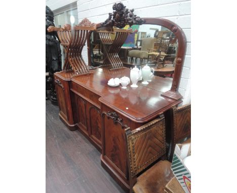 A mid Victorian mahogany chiffonier of large size having foliate crest mirror back with recess frieze drawer and arch double 