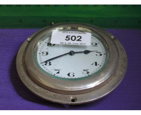 A vintage car clock mounted in chrome bezel
