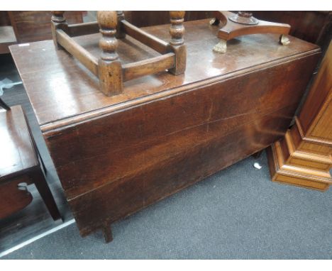 An early 19th century oak dining table having rectangular drop leaf top on square gate legs