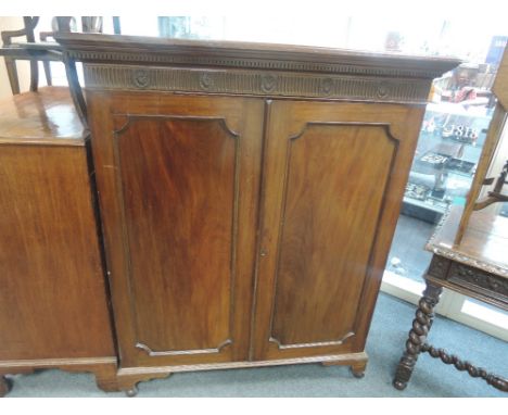 A late Victorian mahogany bookcase having Adam's style frieze decoration with panelled doors on bracket feet