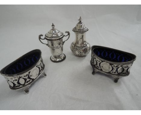 A pair of Victorian silver salts of boat form having pierced decoration, scroll feet and blue glass liners, London 1893 Henry