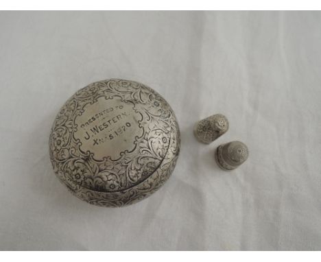 A small silver trinket box of pebble form having a hinged lid and extensive engraved floral and scroll decoration with inscri