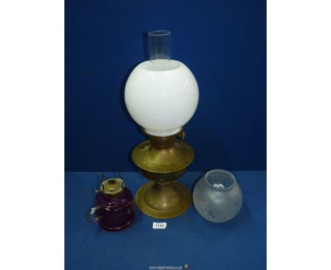 A brass Oil lamp (working) with milk glass globe shade, 19 1/2" tall, plus a red glass oil lamp and an etched glass globe sha