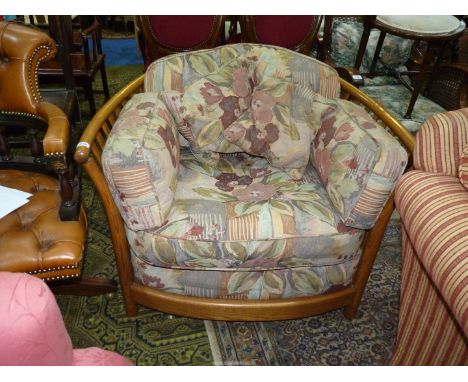 An Ercol slatted sided and backed easy Chair having dark beige ground stylised floral decorated cushions.