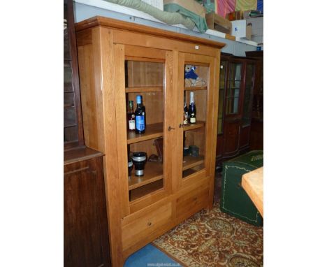 A contemporary light oak display cabinet/bookshelves having a pair of opposing glazed doors over a base with a pair of short 