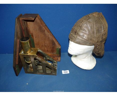 A WWII brass Clinometer by P.T.I. Co. Ltd., no. 2459, dated 1943 and a leather flying cap by Graut & Cockburn Ltd.