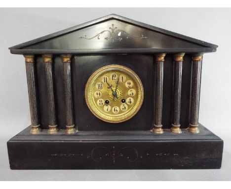 A continental mantel clock of architectural form flanked by reeded columns, the case of Belgian marble with incised decoratio