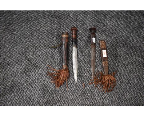 Two African Daggers, one with plain blade, decorated leather  handle and scabbard, one with decorated blade, wooden handle an