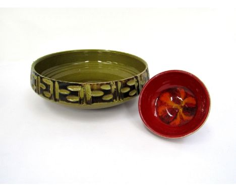 Two Poole Pottery bowls, large relief moulded green glazed example, 29cm x 9cm and a small red Delphis pedestal bowl. (2)