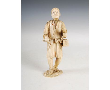 A Japanese sectional ivory okimono of a wood worker, Meiji Period, carved standing holding a box and a chisel, 19.5cm high.