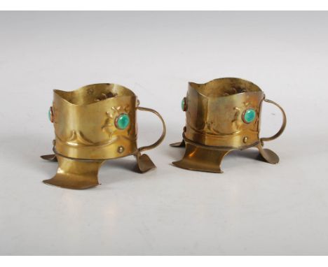 A pair of Arts & Crafts brass chamber candlesticks, each set with three mottled green ceramic cabochon stones within copper s