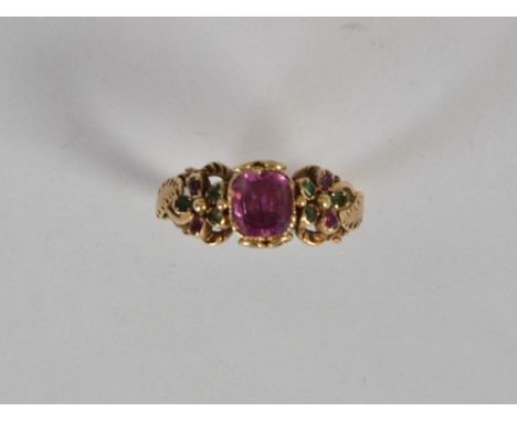 A Victorian ruby and emerald set keeper ring, centred with a square cushion fact cut ruby estimated to weigh 1.06ct, flanked 