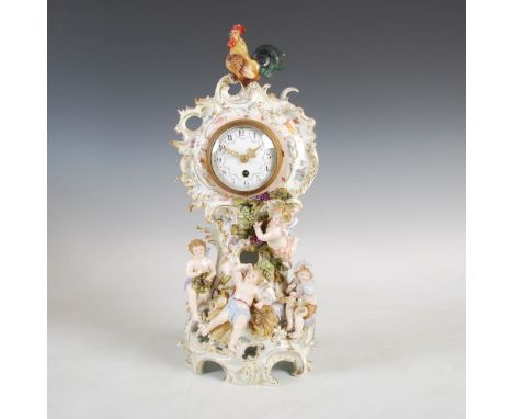 A late 19th century French porcelain mantle clock, the circular enamel dial with Arabic numerals and floral garlands, with pl