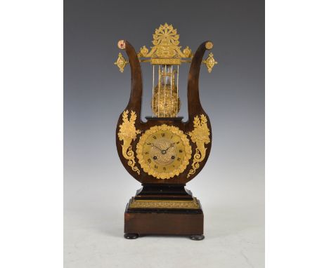 A 19th century Continental, ebonised and ormolu mounted lyre-shaped mantle clock, the circular dial with Roman numerals, the 