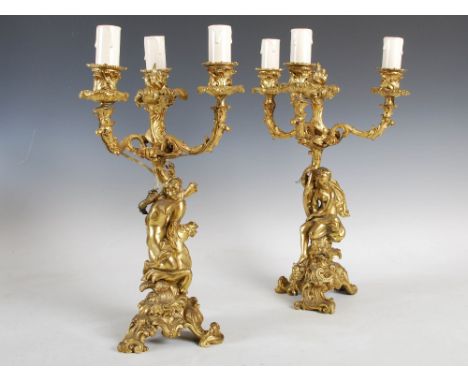 A pair of 19th century French Rococo style ormolu three light candelabra, the foliate cast nozzles and arms supported by a Cl