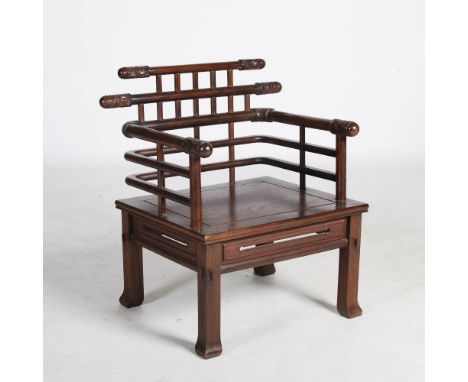 A Chinese hardwood armchair, probably Jichimu, with lattice type back and arms, the horizontals carved with scroll ends above