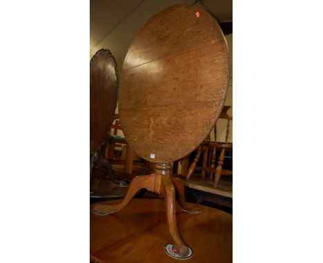 An early 19th century oak circular tilt top tripod table