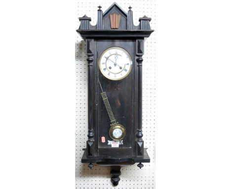 A circa 1900 Vienna stained wood drop trunk wall clock, having a spring driven 8-day striking movement