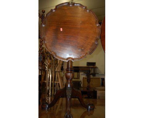 A 19th century mahogany piecrust tilt topped tripod table, raised on acanthus leaf hipped supports to claw and ball feet