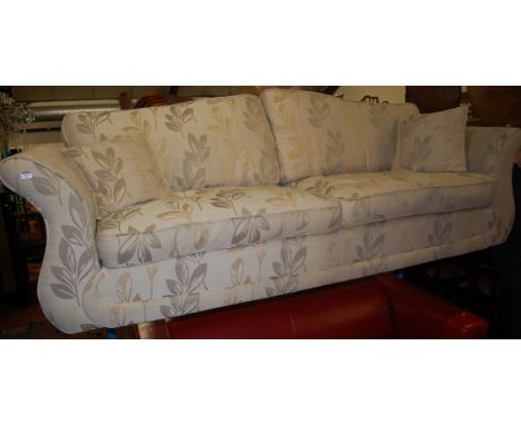 A modern cream floral upholstered three seater sofa